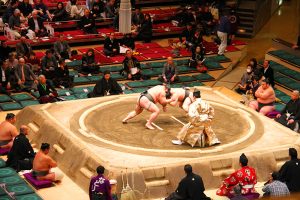 two sumo wrestler fights as the judge watches in and How to Watch Sumo Wrestling Tournaments in Japan